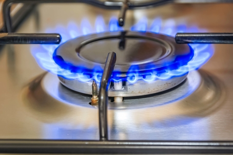 Gas stove with open blue flames.