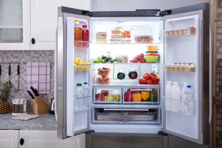 A modern stainless steel fridge opened in a modern kitchen