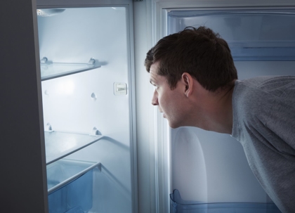 man looking in empty refrigerator