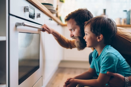 father and son looking in oven