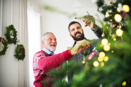 two men decorating Christmas tree