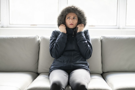 woman wearing parka sitting on couch