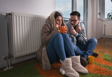 cold couple sitting by radiator