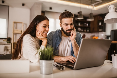 couple making plans on a laptop in the kitchen