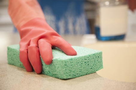 cleaning countertop with sponge