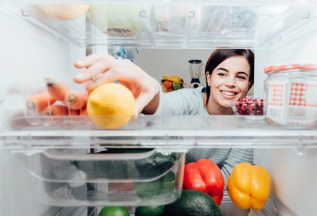 woman reaching into fridge