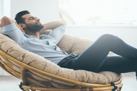 man relaxing on papasan chair