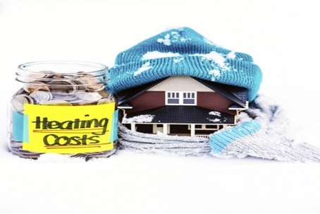 bundled up house beside "heating costs" jar