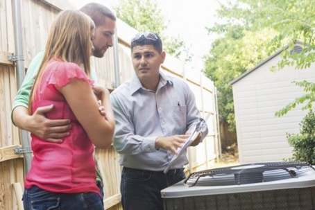 couple talking to AC repair technician