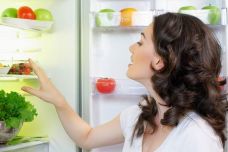 woman looking inside refrigerator